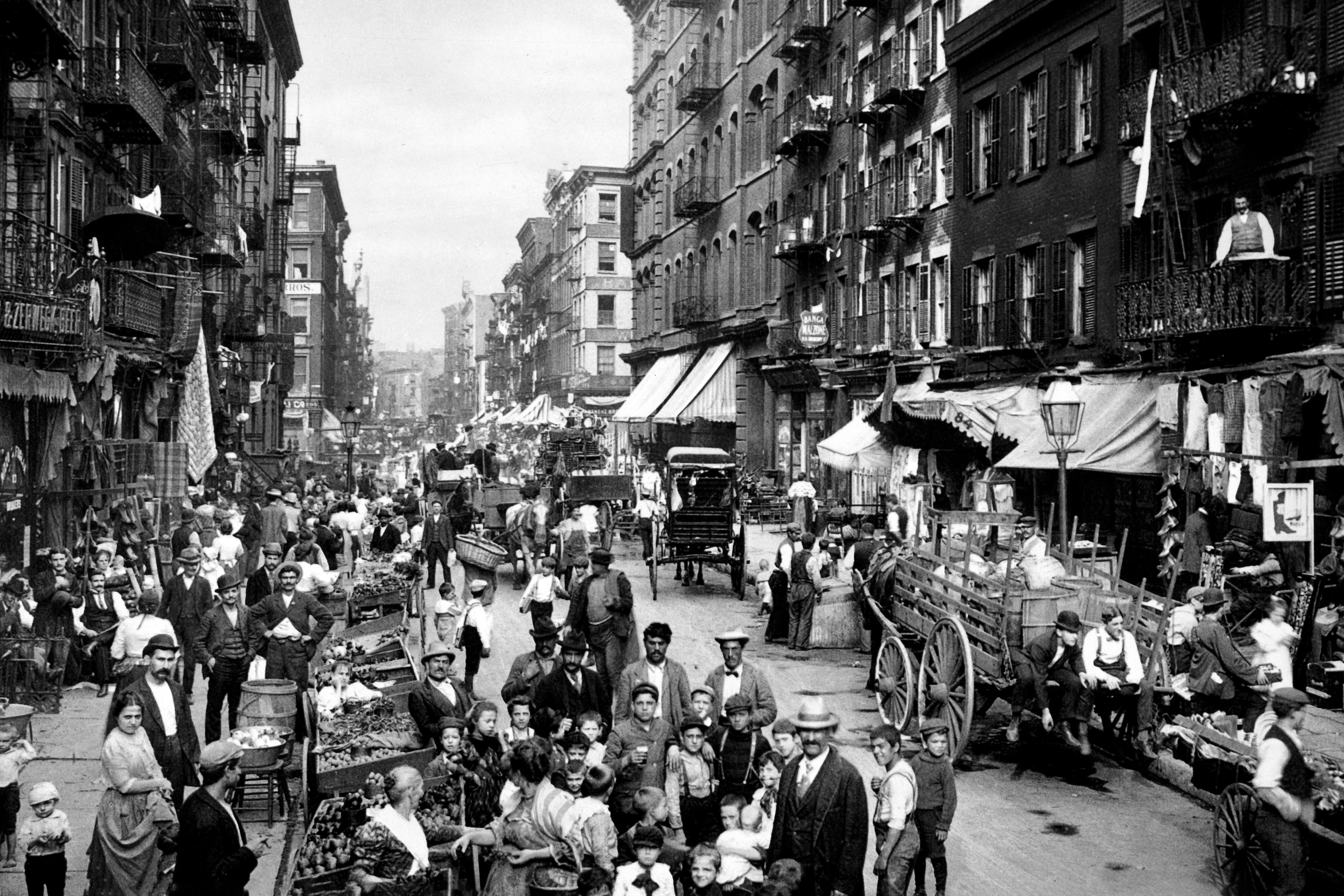 Historic black and white photograph of a bustling and crowded New York City street.